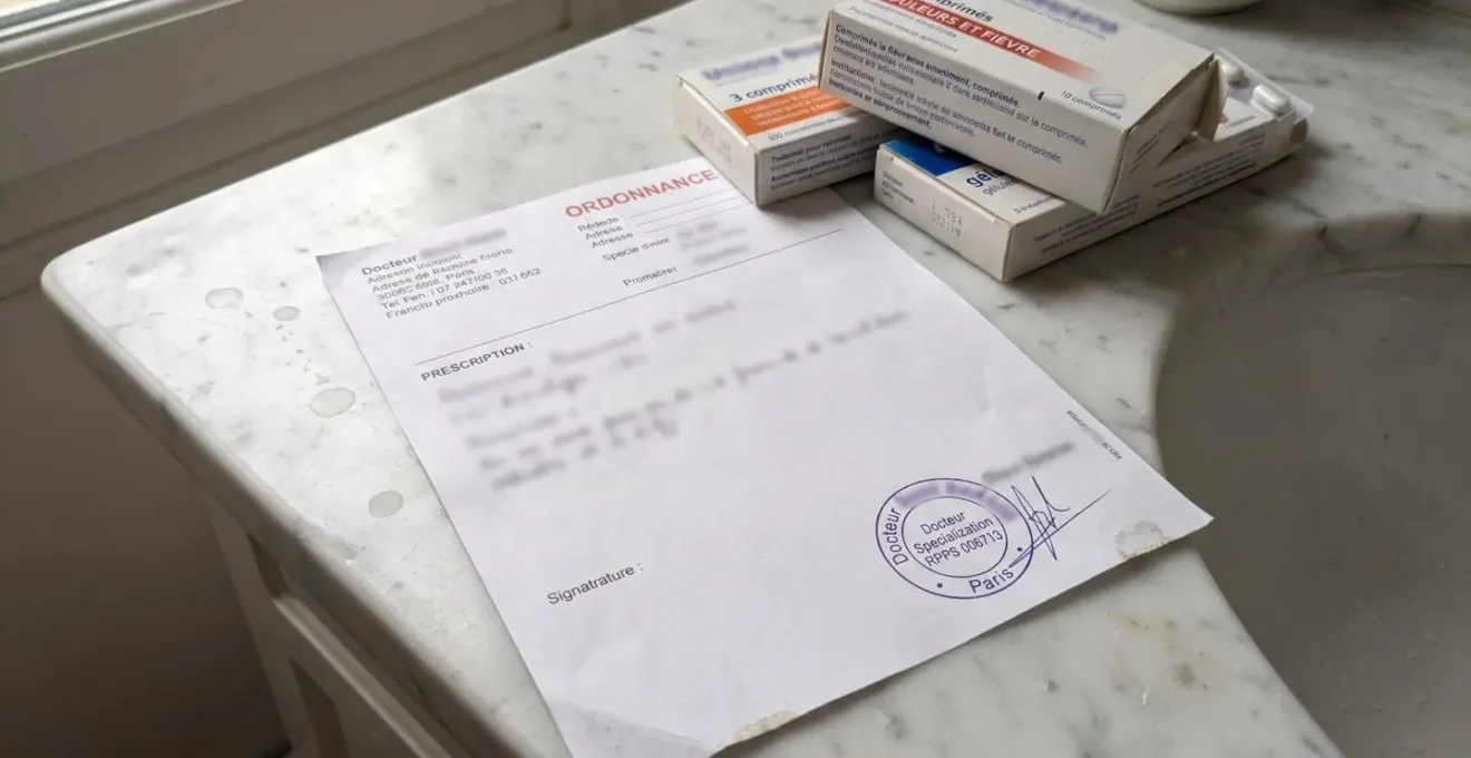 Ordonnance médicale avec tampon de médecin et boîtes de médicaments posées sur un plan de travail blanc